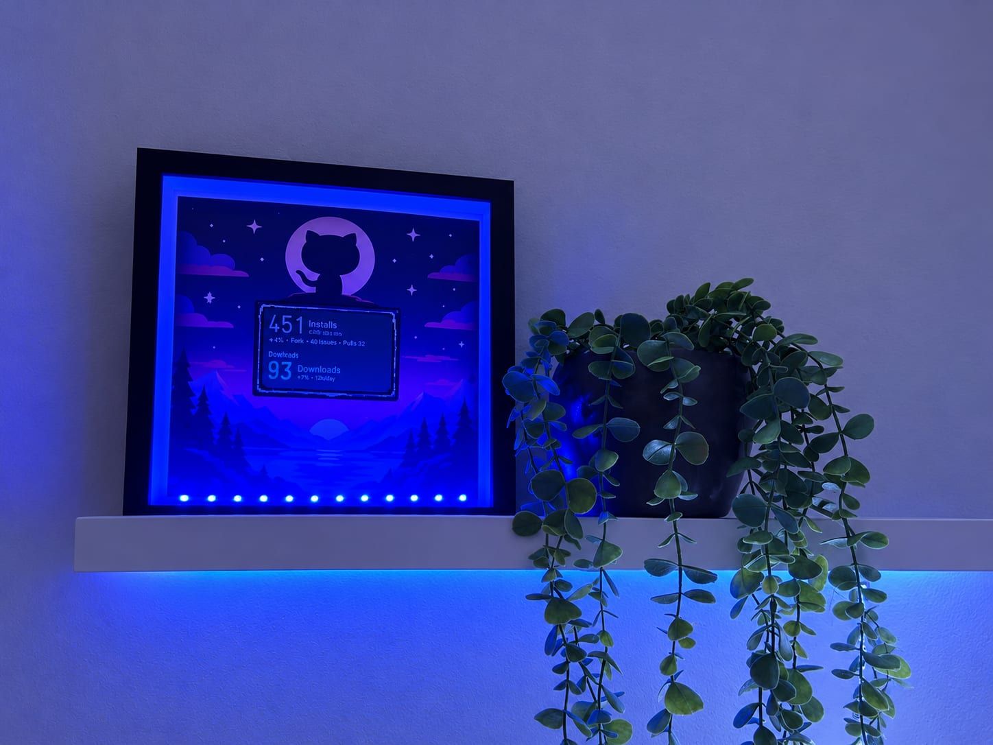 Der fertige Rahmen auf dem Regal: eine Octocat vor einem Nachthimmel, darunter das Display mit 451 Installs von aSPARK und 93 Downloads von Tokibot.
